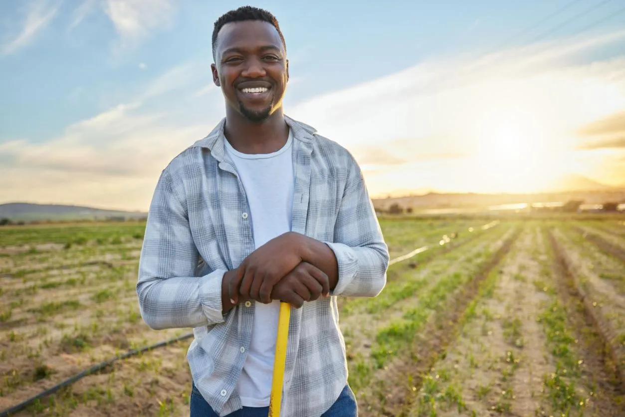 Young farmer standing in cultivated fields